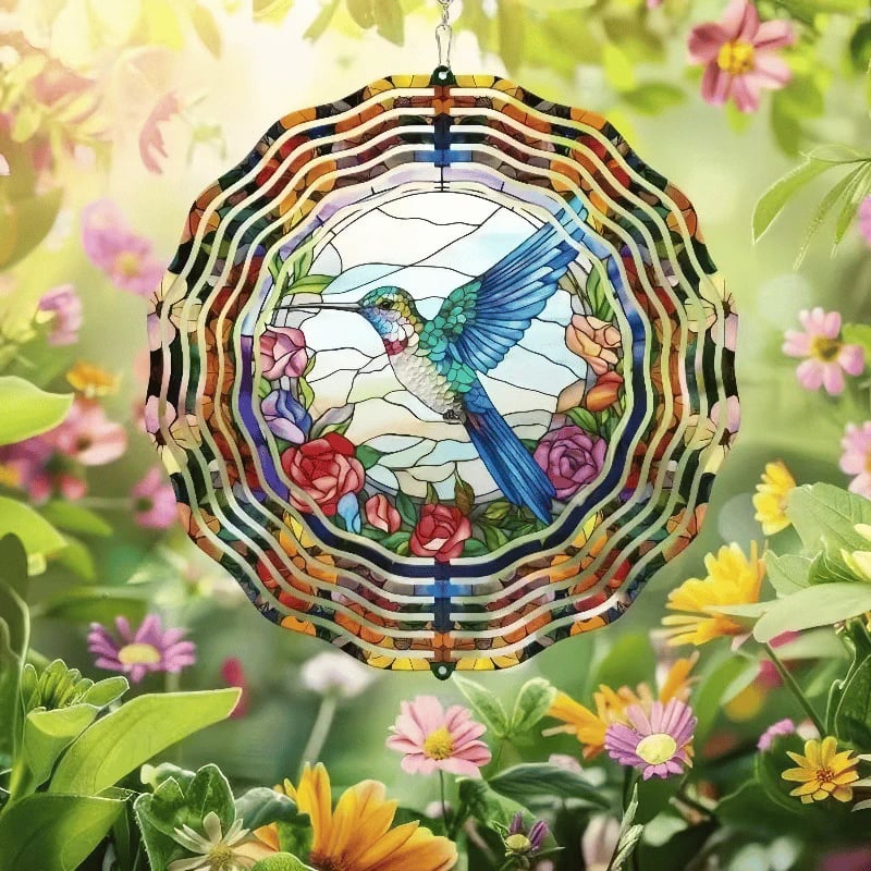 Hummingbird and floral metal wind spinner surrounded by flowers
